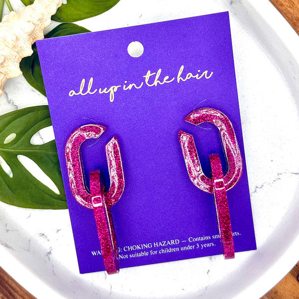 All Up In The Hair | Online Accessory Boutique Located in Mooresville, NC | Two Pink Chunky Chain Earrings on an Indigo colored backer card. The card is laying on two monstera leaves, on a white background.