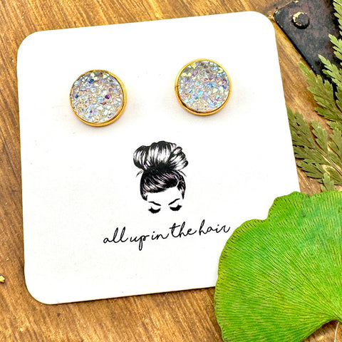 All Up In The Hair | Online Accessory Boutique Located in Mooresville, NC | Two Angel Aura Quartz Druzy set in gold settings. The earrings are on a white, All Up In The Hair branded packaging card. The card is laying on a wood background alongside green leaves.
