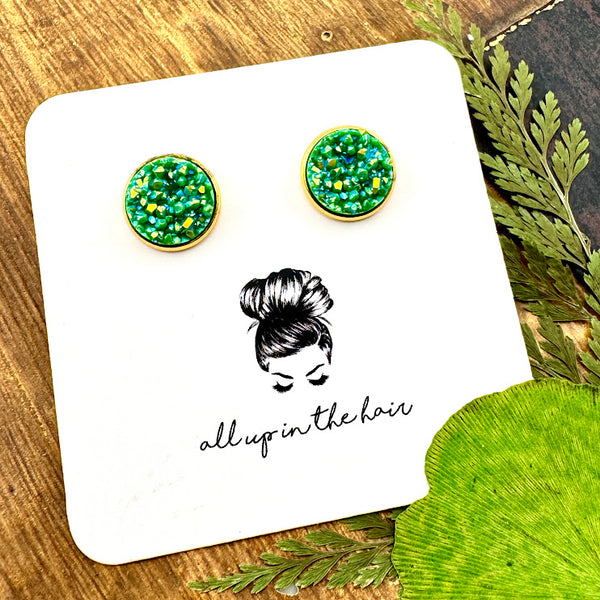 All Up In The Hair | Online Accessory Boutique Located in Mooresville, NC | Two Aventurine Druzy set in a gold stud. The earrings are on a white, All Up In The Hair branded packging card. The card is laying on a wood background alongside green leaves.
