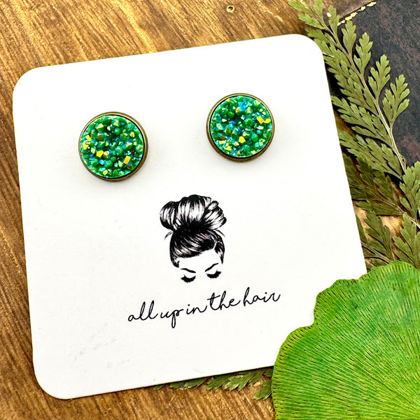 All Up In The Hair | Online Accessory Boutique Located in Mooresville, NC | Two Aventurine Druzy set in a bronze stud. The earrings are on a white, All Up In The Hair branded packging card. The card is laying on a wood background alongside green leaves.