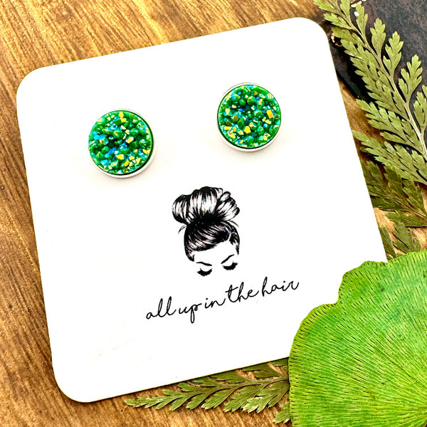 All Up In The Hair | Online Accessory Boutique Located in Mooresville, NC | Two Aventurine Druzy set in a silver stud. The earrings are on a white, All Up In The Hair branded packging card. The card is laying on a wood background alongside green leaves.