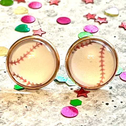 All Up In The Hair | Online Accessory Boutique Located in Mooresville, NC | Two baseball earrings laying on a gray background, surrounded by colorful glitter.