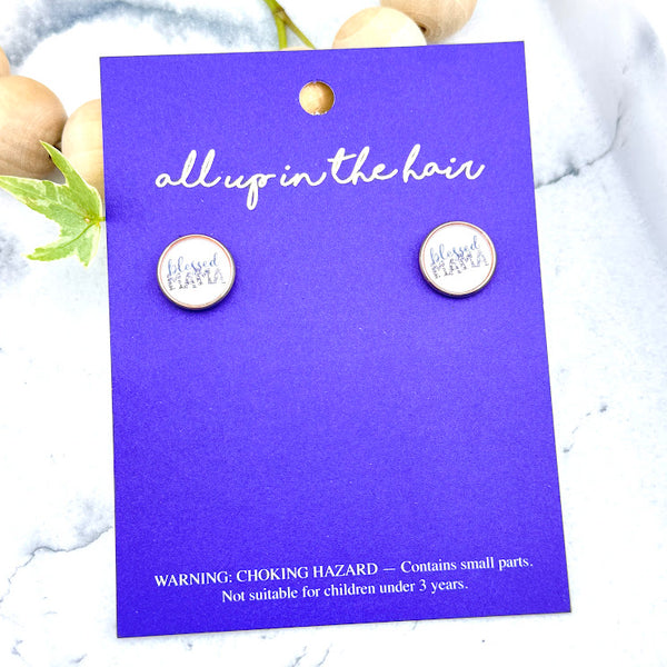 All Up In The Hair | Online Accessory Boutique Located in Mooresville, NC | Two Blessed Mama Earrings on an indigo colored, All Up In The Hair branded packaging card. The card is laying on a white marble background.