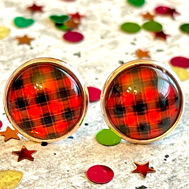 All Up In The Hair | Online Accessory Boutique Located in Mooresville, NC | Close up of two buffalo plaid earrings laying on a gray background, surrounded by colorful glitter.