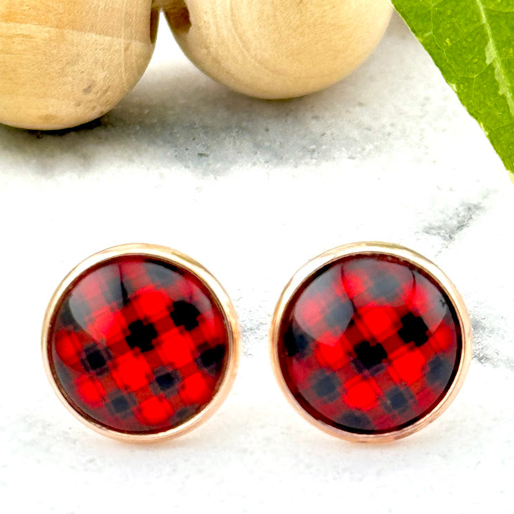 All Up In The Hair | Online Accessory Boutique Located in Mooresville, NC | Two Buffalo Plaid Earrings on a white marble background. Behind the earrings is a wood bead garland and ivy leaves.