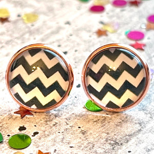 All Up In The Hair | Online Accessory Boutique Located in Mooresville, NC | Close up of two chevron earrings laying on a gray background, surrounded by colorful glitter.