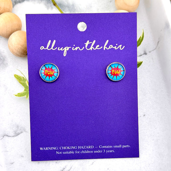 All Up In The Hair | Online Accessory Boutique Located in Mooresville, NC | Two Comic Pow Earrings on an indigo colored, All Up In The Hair branded packaging card. The card is laying on a white marble background.