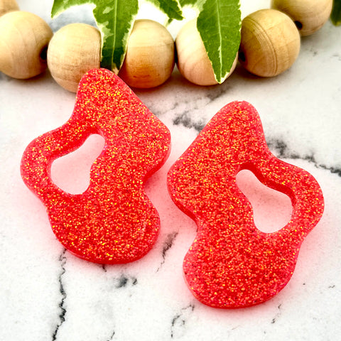 All Up In The Hair | Online Accessory Boutique Located in Mooresville, NC | Two Coral Wave Earrings on a white marble background. There is a wood bead garland and ivy leaves.