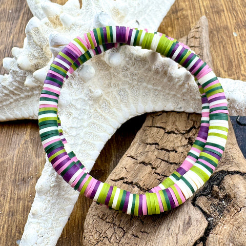 All Up In The Hair | Online Accessory Boutique Located in Mooresville, NC | Two purple, green, and white bracelets are laying on a piece of driftwood and a white starfish.