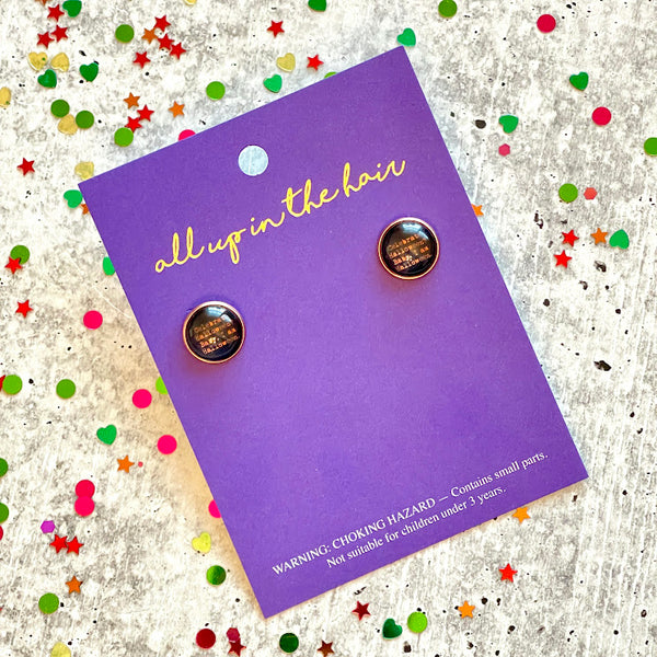 All Up In The Hair | Online Accessory Boutique Located in Mooresville, NC | Two I Am Halloween Earrings on an All Up In The Hair branded packaging card. The card is laying on a gray background, surrounded by colorful glitter.