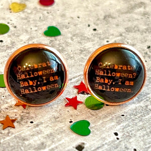 All Up In The Hair | Online Accessory Boutique Located in Mooresville, NC | Two I Am Halloween Stud earrings laying on a gray background, surrounded by colorful glitter.