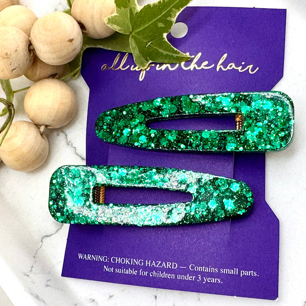 All Up In The Hair | Online Accessory Boutique Located in Mooresville, NC | Our Irish Isles Barrette Set on an indigo colored, All Up In The Hair branded packaging card. The card is laying on a white marble background. At the top of the image is a wood bead garland and ivy leaves.