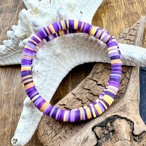 All Up In The Hair | Online Accessory Boutique Located in Mooresville, NC | Two Purple and peach heishi bracelets laying on a piece of driftwood and a white starfish.