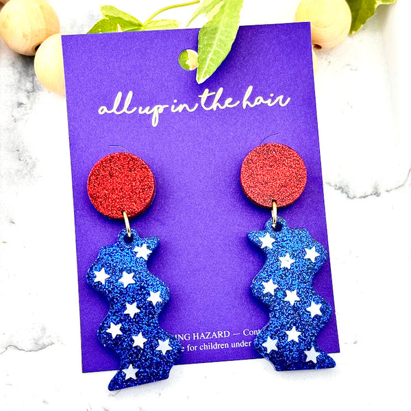 All Up In The Hair | Online Accessory Boutique Located in Mooresville, NC | Two Let Freedom Ring Earrings on an indigo colored, All Up In The Hair branded packaging card. The card is laying on a white marble background.