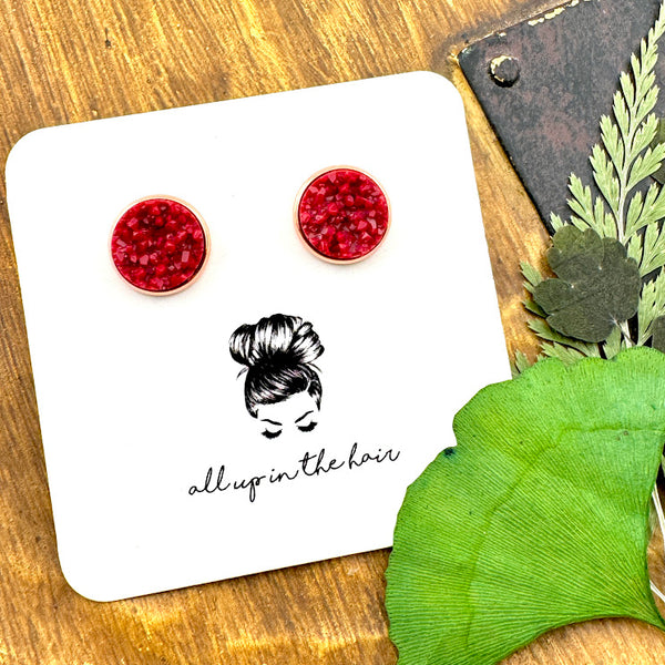 All Up In The Hair | Online Accessory Boutique Located in Mooresville, NC | Two Maroon Druzy in rose gold settings on a white, All Up In The Hair branded packaging card. The card is laying on a wood background next to green leaves.