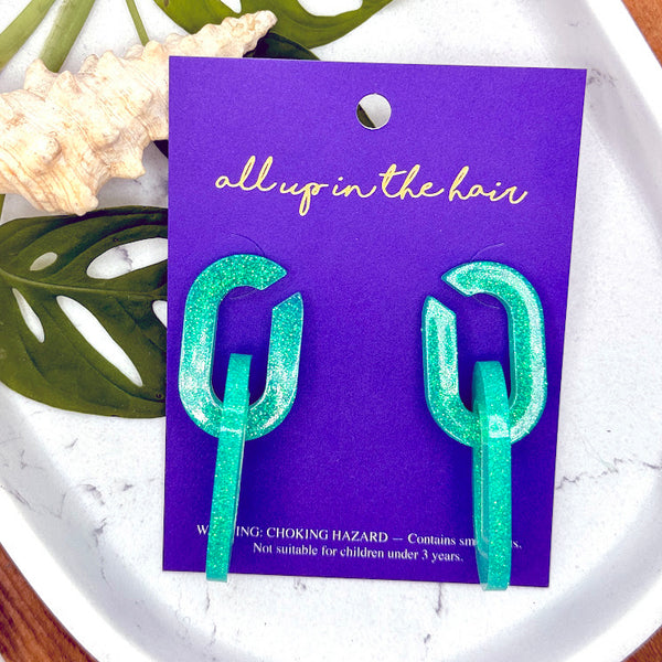 All Up In The Hair | Online Accessory Boutique Located in Mooresville, NC | Two Mint Chain Earrings on an indigo backer card. The card is laying on two monstera leaves on a white marble background.