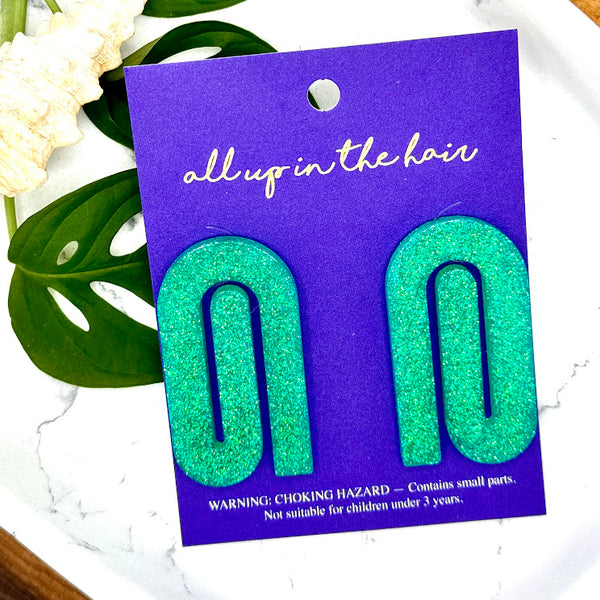 All Up In The Hair | Online Accessory Boutique Located in Mooresville, NC | Two mint paperclip earrinngs on a indigo backer card. The card is laying on two monstera leaves on a white background.