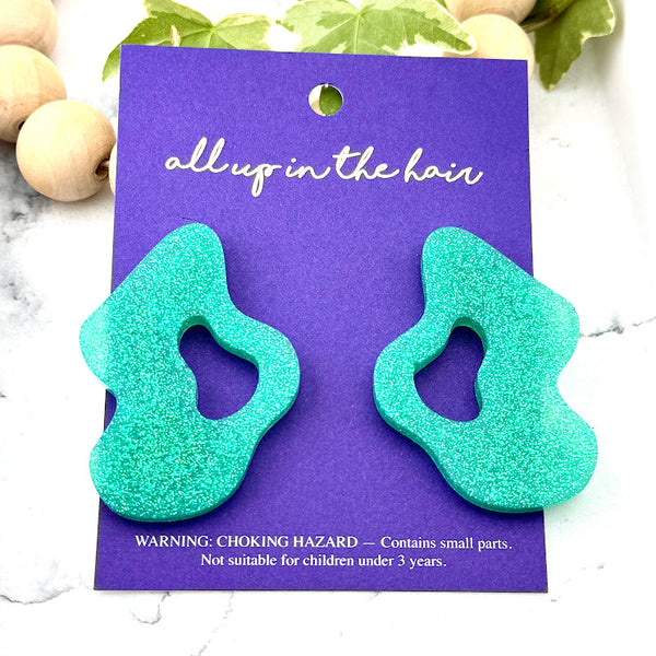 All Up In The Hair | Online Accessory Boutique Located in Mooresville, NC | Two Mint Wave Earrings on an indigo colored, All Up In The Hair branded packaging card. The card is laying on a white marble background.