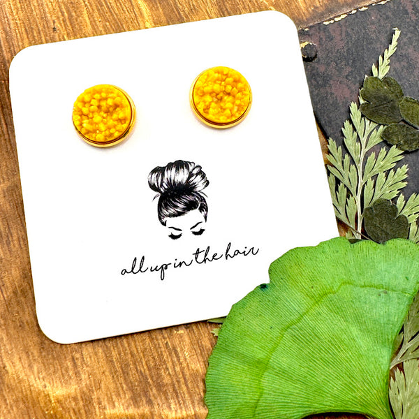 All Up In The Hair | Online Accessory Boutique Located in Mooresville, NC | Two Mustard Druzies in gold setting on a white, All Up In The Hair branded packaging card. The card is laying on a wood background next to leaves.