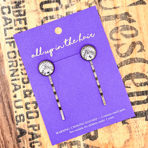 All Up In The Hair | Online Accessory Boutique Located in Mooresville, NC | Two Pewter Mermaid Bobby Pins on an indigo colored, All Up In The Hair branded packaging card. The card is laying on a wood background with black lettering.