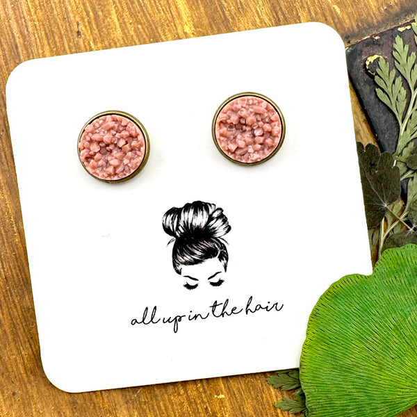 All Up In The Hair | Online Accessory Boutique Located in Mooresville, NC | Two taupe druzies set in bronze settings. The earrings are on a white, All Up In The Hair branded packaging card. The card is laying on a wood background, alongside green leaves.