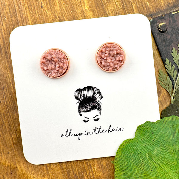 All Up In The Hair | Online Accessory Boutique Located in Mooresville, NC | Two taupe druzies set in a rose gold earring setting. The earrings are on a white, All Up In The Hair branded packaging card. The card is on a wood background alongside green leaves.