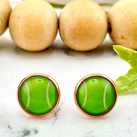 All Up In The Hair | Online Accessory Boutique Located in Mooresville, NC | Two Tennis Ball Earrings on a white marble background. There is a wood bead garland and ivy leaves behind the earrings.