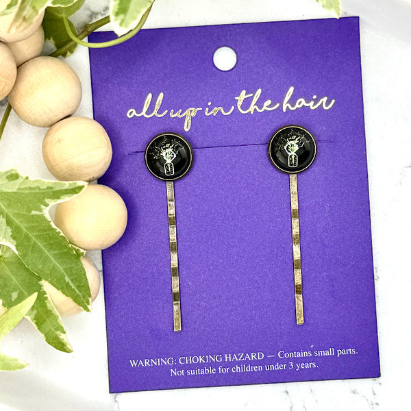 All Up In The Hair | Online Accessory Boutique Located in Mooresville, NC | Two Wildflower Bobby Pins on an indigo colored, All Up In The Hair branded packaging card. The card is laying on a white marble background alongside a wood bead garland and ivy leaves.