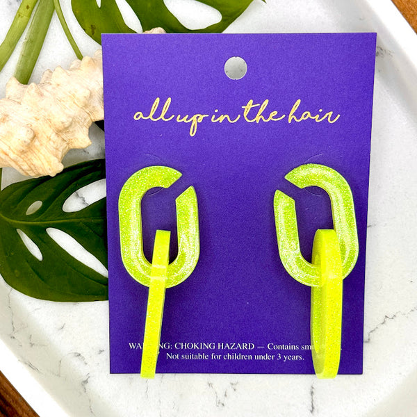All Up In The Hair | Online Accessory Boutique Located in Mooresville, NC | Two Yellow Chunky Chain Earrings on an indigo backer card. The card is laying on monstera leaves on a white background.