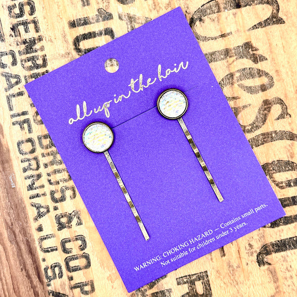 All Up In The Hair | Online Accessory Boutique Located in Mooresville, NC | Two Yellow Mermaid Bobby Pins on an indigo colored, All Up In The Hair branded packaging card. The card is laying on a wood background with black lettering.