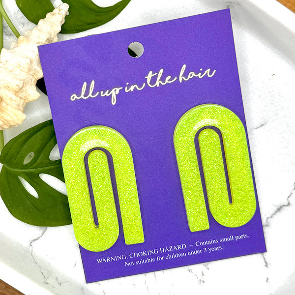 All Up In The Hair | Online Accessory Boutique Located in Mooresville, NC | Two Yellow Paperclip Earrings on an indigo backer card, laying on monstera leaves on a white background.