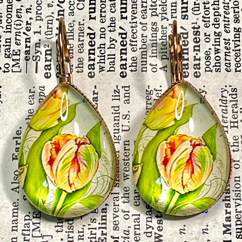 All Up In The Hair | Online Accessory Boutique Located in Mooresville, NC | Two Yellow Teardrop Dangle Earrings laying on a book page.