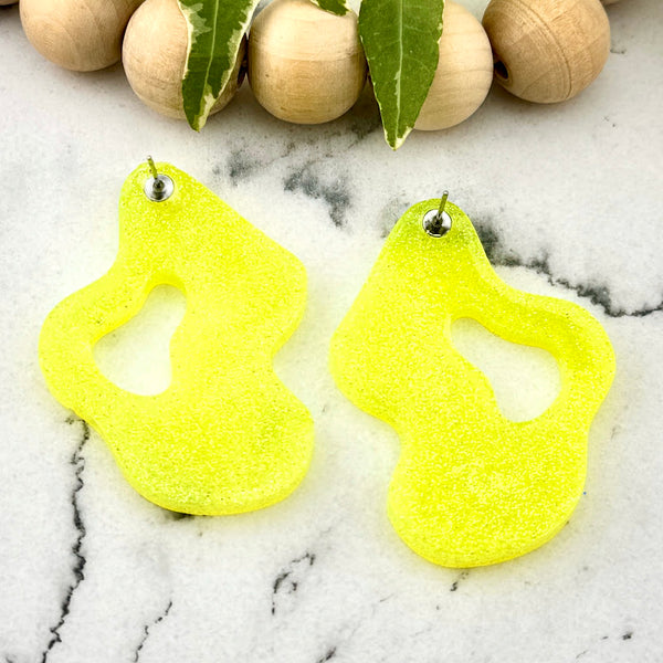 All Up In The Hair | Online Accessory Boutique Located in Mooresville, NC | Back of two Yellow Wave Earrings on a white marble background.