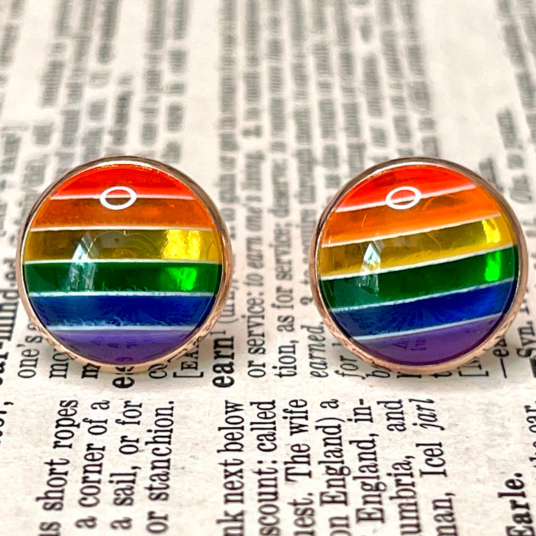 All Up In The Hair | Online Accessory Boutique Located in Mooresville, NC | Close up of two rainbow earrings on a book page.